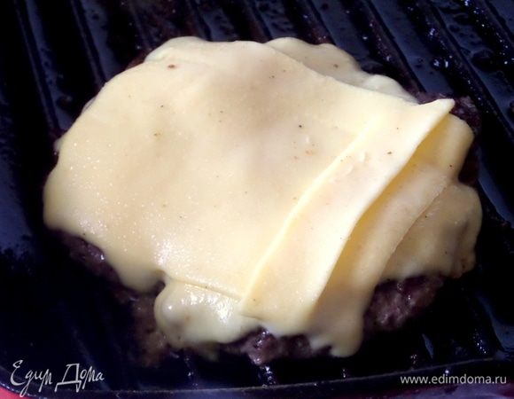 Котлетку перевернуть и перенести пластинками сыр сверху 2–3 ломтика.