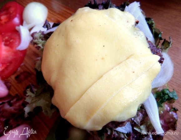 Переносим на салат готовую котлетку с сыром. Сверху — кусочки бекона.