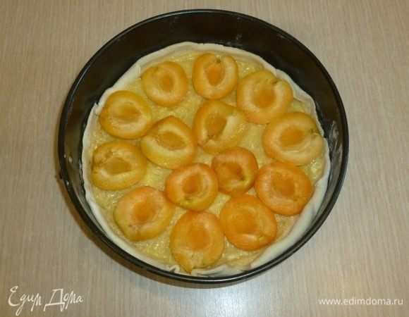 Выложить крем на тесто и разровнять. Разложить сверху половинки абрикосов.