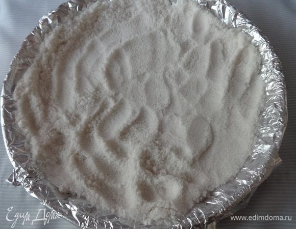 На тесто положить фольгу и насыпать слой соли (или фасоли, гороха). Поставить форму с тестом в духовку, разогретую до 180°C. и выпекать в течение 20 минут.