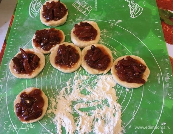 Из теста сформируйте булочки или ватрушки. Смажьте их взбитым яичным желтком и оставьте на противне на 10 минут, чтобы поднялись края булочек. Сверху на тесто положите начинку из варенья. Оно может быть любым. Крахмал нужен для того, чтобы начинка не растеклась.