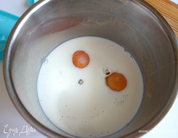 В молоко добавить яйца, ванильный сахар и ванильную эссенцию. Перемешать.