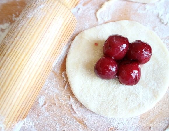 На кусочек теста положить несколько вишен. Жидкость от вишен не использовать, вишни и так довольно сочные, пропитанные вином.