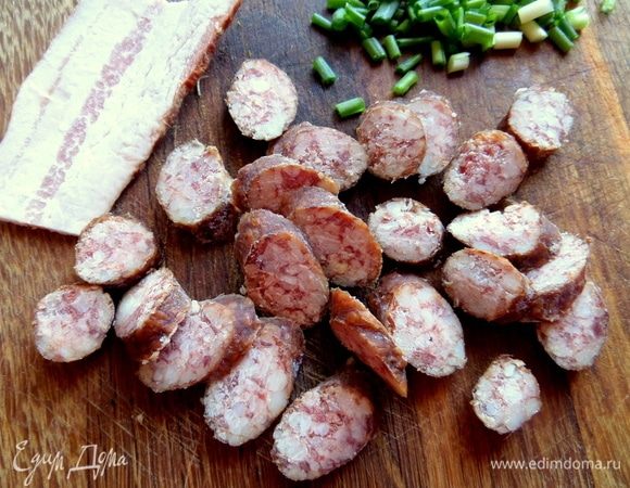 Колбаску длинную или полоску бекона нарезать.