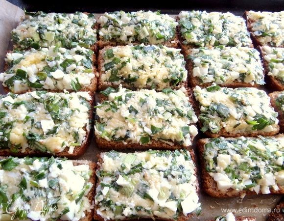Нанести начинку на ломтики и поместить на противень с пергаментом, смазав его маслом.
