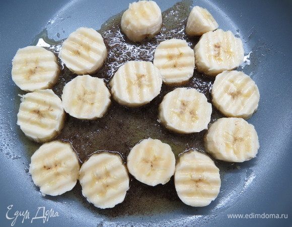 Готовим карамелизированные бананы. Сливочное масло растопить на сковороде, всыпать ванильный сахар с натуральной ванилью, дождаться растворения крупинок сахара. Вместо ванильного сахара также можно использовать ванильный экстракт (1 ст. л.). Банан нарезать кружочками, выложить на сковороду.