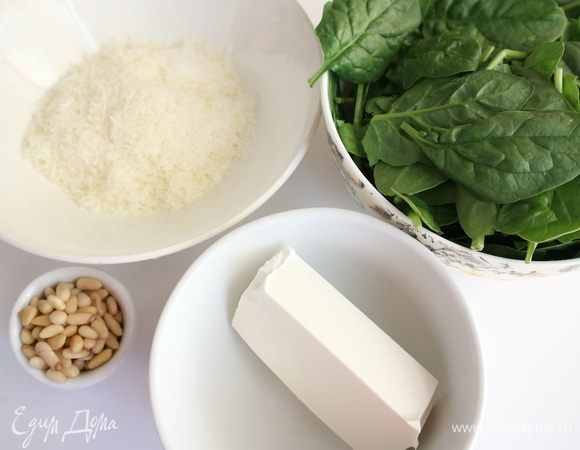 Приготовить начинку. Шпинат поместить на 1 минуту в кипящую подсоленную воду, откинуть на дуршлаг, дать остыть, отжать. Нарезать мелко. Жидкость из упаковки с брынзой не выливать, она понадобится.