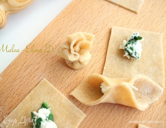 Скрепить края, подтянув по диагонали противоположные концы к центру, закрепить их, чтобы получился мешочек из теста с начинкой, верхняя часть состоит из складочек теста.