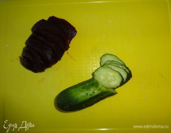 Вареную свеклу нарезать тонкими ломтиками, огурец нарезать тонкими кружками.