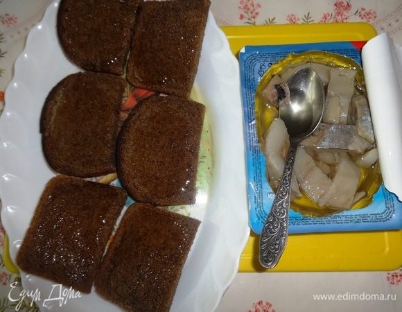 Кусочки хлеба смазать маслом из баночки с селедкой.
