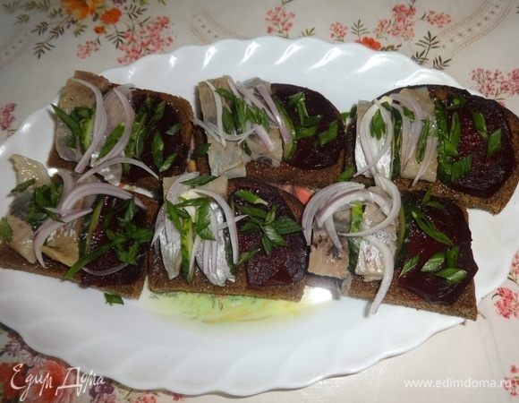 Кружки огурцов разрезать пополам и положить на хлеб. Посыпать репчатым и зеленым луком.