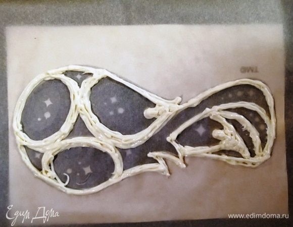 Под пергамент я положила рисунок эмблемы. Прорисовываем белую часть. Отправляем в духовку, разогретую до 180⁰С, на 7 минут.