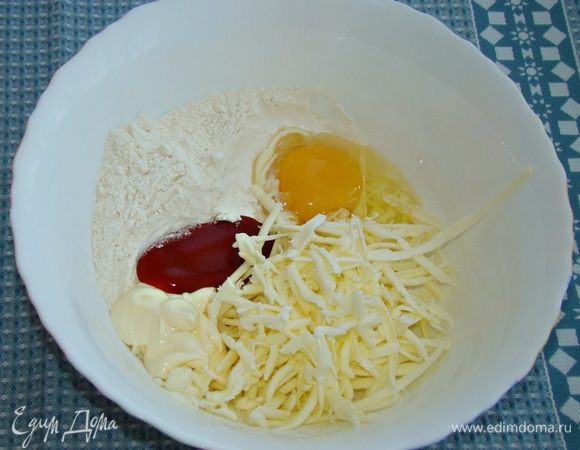Добавить яйцо, майонез, кетчуп, соль и натертый на мелкой терке сыр.
