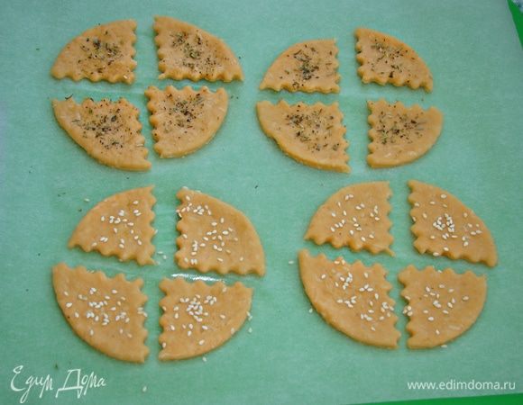 По желанию, печенье можно посыпать кунжутом или специями. В данном случае у меня итальянские травы, что добавило печенью ароматного и пикантного вкуса. Выпекать в разогретой до 180°C духовке минут 10–15, до румяного цвета.