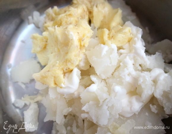 Размять картофель в пюре, добавив сливочное масло с чесноком и специями, сливки, затем — половину натертого пармезана.