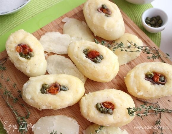 В центр каждой картофелины поместить по одному анчоусу, несколько каперсов и вяленые томаты в масле.