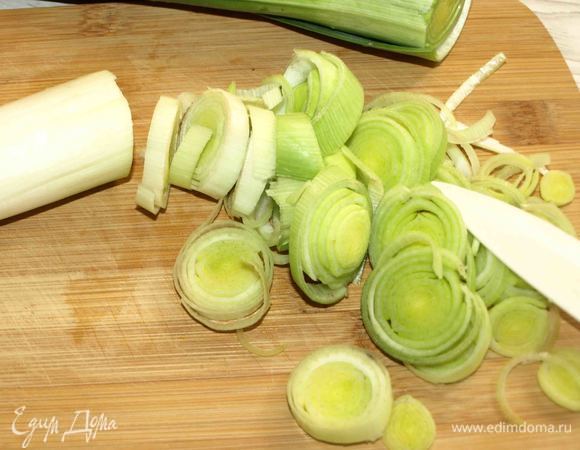 Лук-порей промыть. Отделить белую часть. Зеленую выбрасывать не надо (использовать для бульона). Белую часть нарезать кольцами.