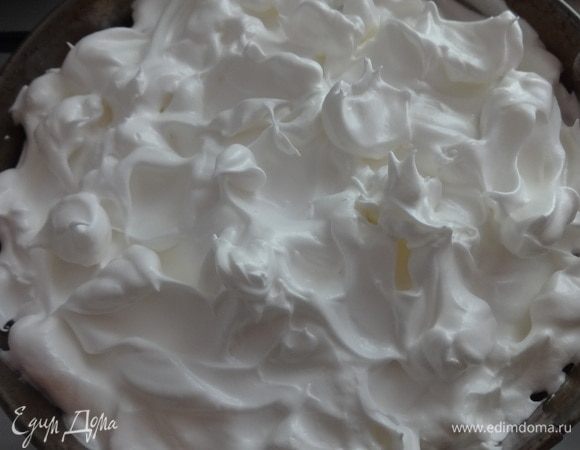 Сверху положить слой безе. Его можно выкладывать ровным слоем, а можно фигурно. Поставить форму с пирогом в духовку еще минут на 10–15 до легкого подрумянивания безе.