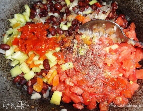 Помидоры, сладкий и горький перец, пюре из перца добавить в сковороду с фасолью. Посолить, поперчить, перемешать.
