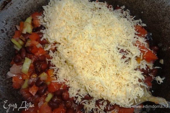 Отложить 1/4 часть сыра, остальной сыр выложить в сковороду с овощами и фасолью, перемешать.