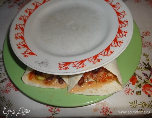 Чтобы сыр расплавился и держал закуску «в форме», можно поставить буррито в духовку или в СВЧ-печь. Я делала так: на большую тарелку выкладывала 2 буррито, сверху ставила тарелку поменьше. всю эту конструкцию помещала в микроволновку на 1 мин. при полной мощности.