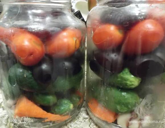 На дно подготовленных банок кладем чеснок и морковь. Уложить слой огурцов, слой слив без косточки, слой помидоров.