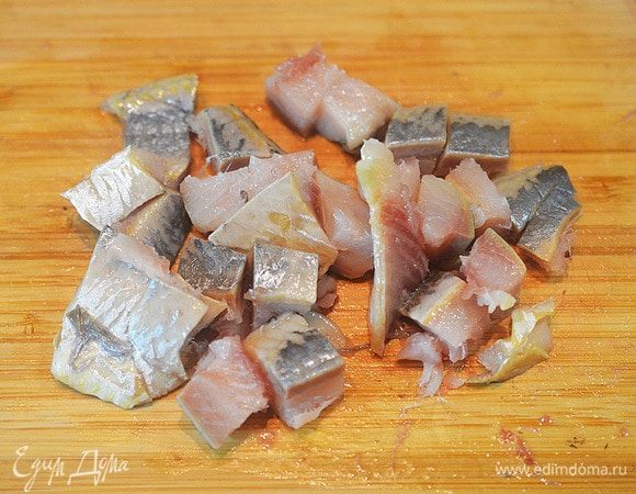 Нарежьте сельдь на кусочки произвольно.