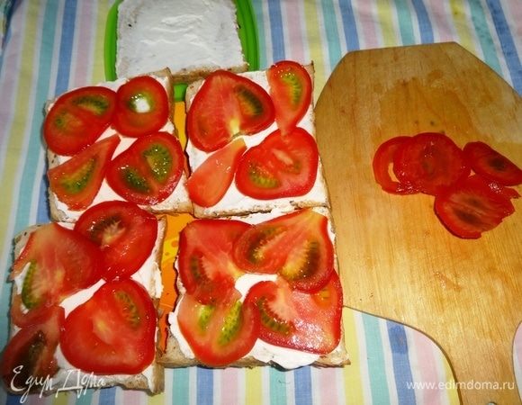 Помидоры вымыть, обсушить, нарезать тонкими пластинками и уложить поверх сыра.
