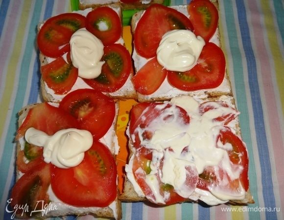 На помидоры выложить майонез и распределить по всей поверхности.