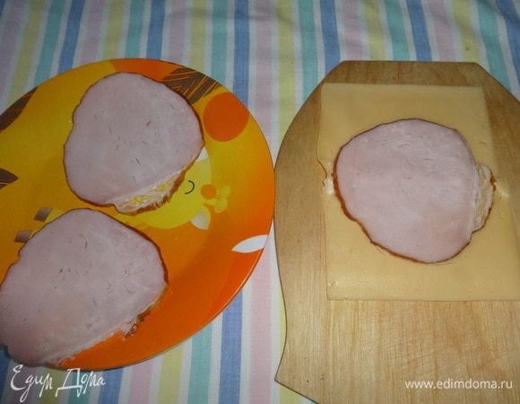 Две пластины сыра сложить встык друг к другу, на них положить кружок карбонада. Обвести форму круга на сыре.