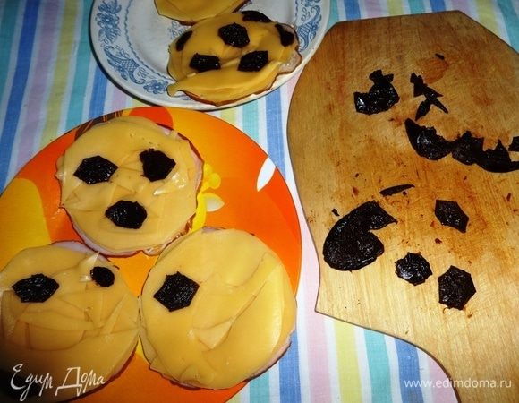 Чернослив вымыть, залить на 5 минут горячей водой. Воду слить, чернослив обсушить. Из кусочков чернослива вырезать шестиугольники и уложить из поверх сыра, чтобы было похоже на футбольный мяч, маленькие обрезки уложить по бокам.