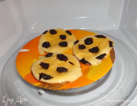 Кружки карбонада с сыром и черносливом выложить на тарелку и поставить на 30 секунд в микроволновку при полной мощности.