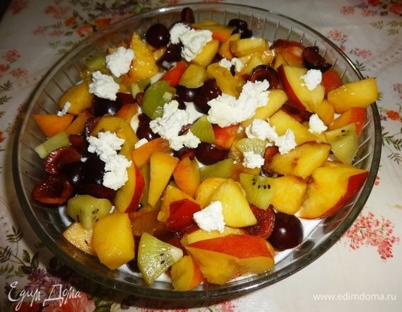 Соединить сметану и мацони, перемешать. Выложить смесь на дно салатника. В сметанную массу выложить все подготовленные фрукты. Сверху положить вразброс маленькие кусочки мягкого сыра.