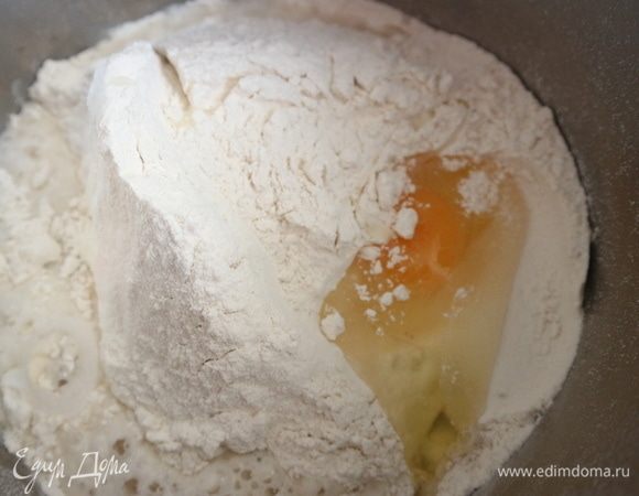 Добавить яйцо, соль, воду, оливковое масло. Перемешать миксером с насадками-крюками сначала недолго на минимальной скорости, затем скорость увеличить, перемешать.