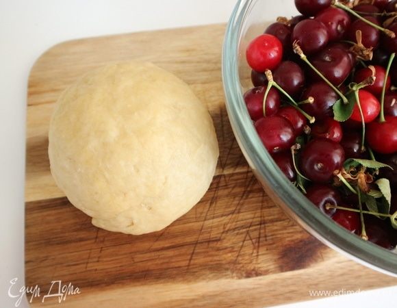 Заканчиваем перемешивать тесто руками на рабочей поверхности. Тесто должно быть однородным и эластичным. Скатать его в шар. Вишню вымыть, откинуть на дуршлаг, чтобы она просохла.