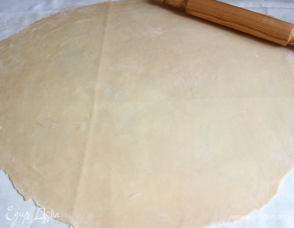 Технология дальнейшей раскатки: еще раскатать скалкой от центра к краям, затем просунуть под тесто руки ладонями вниз (костяшками пальцев вверх), согнуть пальцы в кулак, большой палец зажать в кулак, тесто приподнять и растянуть, помещая кулаки в разные части теста, растягивая его немного, затем раскатать, потом опять растянуть руками, раскатать.