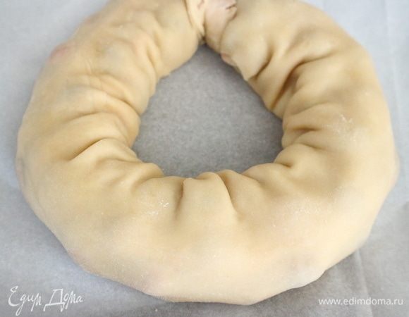 Рулет аккуратно положить на противень, покрытый бумагой для выпечки. Скрутить кольцом, скрепить края.