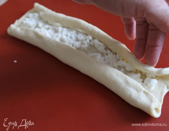 Края вместе с сырной начинкой с каждой стороны подверните два раза к середине. Сформируйте два валика.