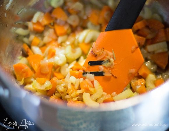 Лук, морковь и сельдерей нарезать мелкими кубиками, чеснок измельчить. В большой кастрюле разогреть масло, сложить в нее лук, морковь, сельдерей, чеснок и розмарин, готовить на среднем огне 5 минут, помешивая.
