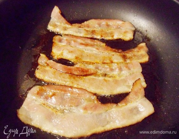 Тонкие ломтики бекона (у меня готовый сырокопченый нарезанный бекон) выложить на разогретую сухую сковороду. Обжарить бекон с двух сторон до золотисто-коричневого цвета.