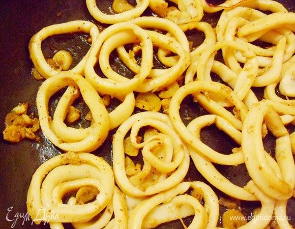 Добавить соль и черный свежемолотый перец. Жарить, непрерывно помешивая, не более 4 минут. Самое главное — не передержать кальмары на огне, иначе они станут просто резиновыми!