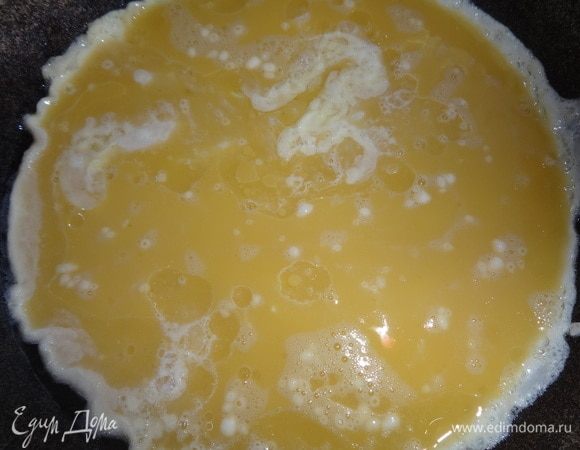 В сковороду налить растительное масло, разогреть. Вылить яичную массу и поджарить с одной стороны на небольшом огне в течение нескольких минут. Дождаться, когда немного схватится верх омлета.
