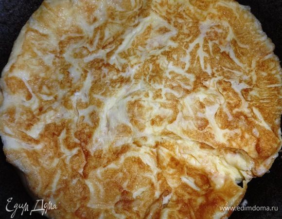 Аккуратно с помощью лопатки (или двух) перевернуть омлет на другую сторону и жарить еще пару минут.