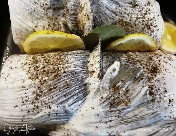 Укладываем рулеты на противень, смазываем их сметаной, солим и перчим. Между рулетами укладываем дольки лимона и лавровый лист. Запекаем в духовке 17 минут при 180°C.