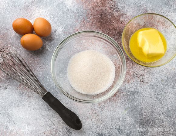 Взбейте куриные яйца с сахаром до образования пышной белой пены. Удобным способом растопите сливочное масло, остудите.<br />
 