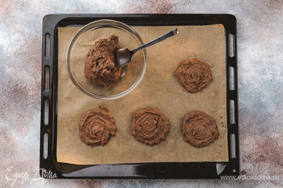 Противень застелите бумагой для выпечки. Ложкой выложите порционно заготовки печенья. Выпекайте при 180°С 15–20 минут.