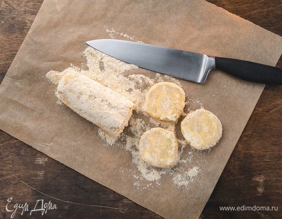 Рабочую поверхность посыпьте оставшейся кедровой мукой. Раскатайте тесто в колбаску диаметром примерно 5 см. Нарежьте ее кружками толщиной 1,5 см. Обваляйте каждый сырник в муке.