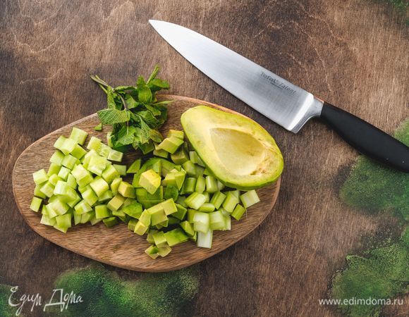 Авокадо и огурцы очистите. Нарежьте кубиками авокадо, огурцы, сельдерей. Измельчите листья мяты.