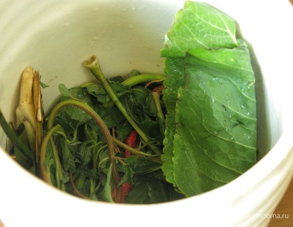 На дно бутылька (бочонка) кладем зелень.