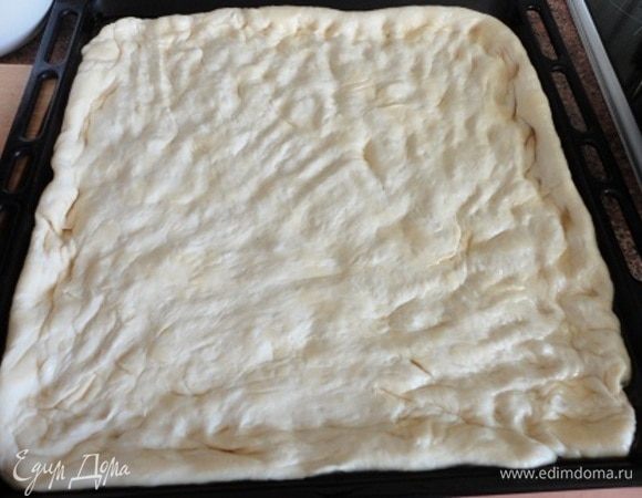 Духовку желательно разогреть до 280°C или на сколько максимально возможно на вашей духовке. Нежно руками распределите тесто по всему противню.